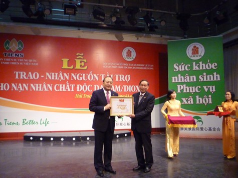 Đại diện Trung ương Hội nạn nhân chất độc màu da cam/dioxin Việt Nam trao giấy chứng nhận Tấm lòng vàng cho Công ty TNHH Thiên Sư Việt Nam. (Ảnh Thu Hòe)